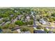 An aerial view of a home in a neighborhood surrounded by lush greenery and a tranquil lake at 132 Margate Mews, Longwood, FL 32779