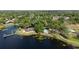 Stunning aerial view of the property with a pool, lake frontage, a private dock, and lush surroundings at 132 Margate Mews, Longwood, FL 32779