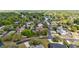 An aerial view of a home in a neighborhood surrounded by lush greenery and a tranquil lake at 132 Margate Mews, Longwood, FL 32779