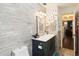 Charming bathroom with wood-look tile, vanity with gray cabinets, and decorative silver accent wall at 132 Margate Mews, Longwood, FL 32779