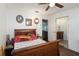 Relaxing bedroom features a wooden bed frame, ceiling fan, and an adjacent view of the bathroom at 132 Margate Mews, Longwood, FL 32779