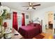 Comfortable bedroom with hard wood floors, bright red curtains, and matching red bed spread at 132 Margate Mews, Longwood, FL 32779