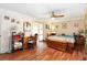 Bright bedroom boasts hardwood floors, ceiling fan, large window, and office setup in a comfortable atmosphere at 132 Margate Mews, Longwood, FL 32779