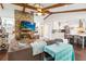 Open-concept living room boasts vaulted ceilings with wood beams, a brick fireplace, and seamless flow to the modern kitchen at 132 Margate Mews, Longwood, FL 32779