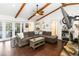 Comfortable living room featuring hardwood floors, exposed beams, and large sectional sofa at 132 Margate Mews, Longwood, FL 32779