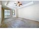 Inviting bedroom with tray ceiling, ceiling fan, and ample natural light at 2376 Home Again Rd, Apopka, FL 32712