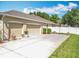 Spacious three-car garage with a large driveway, basketball hoop, and well-maintained landscaping at 2376 Home Again Rd, Apopka, FL 32712