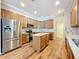 Modern kitchen with stainless steel appliances, an island, wood floors, and stone countertops at 2376 Home Again Rd, Apopka, FL 32712