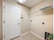 Efficient laundry room featuring tile flooring, shelving, and a utility sink hookup at 2376 Home Again Rd, Apopka, FL 32712