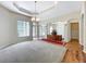 Open living room featuring a tray ceiling, chandelier, archways, and elegant hardwood flooring at 2376 Home Again Rd, Apopka, FL 32712