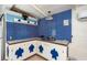 Coastal kitchen featuring turtle-themed cabinetry, blue tile accents, and white beadboard walls, creating a beachy atmosphere at 370 Hartford Ave, Daytona Beach, FL 32118