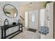 Inviting entryway with tiled floor, and decorative brick wall with large round mirror and charming console table at 4133 Staffordshire Dr, Lakeland, FL 33809