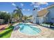 A sparkling in-ground pool is surrounded by a brick patio and lush landscaping at 4133 Staffordshire Dr, Lakeland, FL 33809