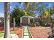 A backyard shed surrounded by manicured landscaping with mulch and brick pavers at 4133 Staffordshire Dr, Lakeland, FL 33809