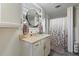 Charming bathroom with vanity, round mirror, and shower/tub featuring a stylish, floral curtain at 4719 Dove Cross Dr, Lakeland, FL 33810