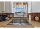 Close-up of a kitchen sink with modern fixtures, surrounded by decorative backsplash tiles and a window view at 4719 Dove Cross Dr, Lakeland, FL 33810