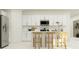 Bright kitchen featuring white cabinets, stainless steel appliances, and a functional island with bar stools at 4738 Bold Peacock Bnd, Bartow, FL 33830