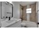 Modern bathroom featuring a quartz countertop vanity and a tiled shower-tub combo with black trim at 5349 Hidden Oaks Dr, Lakeland, FL 33811