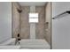 Tiled bathroom features a tub and shower combination with black hardware and a built-in niche at 5349 Hidden Oaks Dr, Lakeland, FL 33811