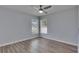 A bright bedroom features two windows, wood-look floors, and a ceiling fan for added comfort at 5349 Hidden Oaks Dr, Lakeland, FL 33811