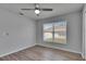 A bright bedroom with wood-look floors, a ceiling fan, and large windows offering natural light at 5349 Hidden Oaks Dr, Lakeland, FL 33811