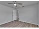 Neutral bedroom featuring wood-look floors, a ceiling fan, and a closet with easy access to another room at 5349 Hidden Oaks Dr, Lakeland, FL 33811