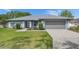 Charming single-story home featuring a well-maintained lawn, gray exterior, and a two-car garage at 5349 Hidden Oaks Dr, Lakeland, FL 33811