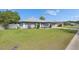 Cozy home with green lawn, gray exterior paint, and two-car garage at 5349 Hidden Oaks Dr, Lakeland, FL 33811