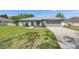 Well-manicured lawn and tidy landscaping complement this gray single-story home with a two-car garage at 5349 Hidden Oaks Dr, Lakeland, FL 33811