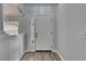 View of the home's white front door with sidelight, set against a gray wall and wood-look flooring at 5349 Hidden Oaks Dr, Lakeland, FL 33811