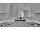 Modern kitchen featuring white cabinetry, subway tile backsplash, and stainless steel sink and faucet at 5349 Hidden Oaks Dr, Lakeland, FL 33811