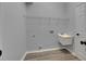 Laundry room with utility sink, white walls, and wire shelving for storage solutions at 5349 Hidden Oaks Dr, Lakeland, FL 33811