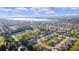 Wide aerial shot highlighting the residential neighborhood, adjacent to a long, narrow lake and sprawling greenery at 10367 Addison Shore Way, Oxford, FL 34484