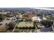Aerial view of community clubhouse, pool, and tennis courts with parking and lush green landscaping at 10367 Addison Shore Way, Oxford, FL 34484