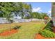 A spacious backyard with a white fence, manicured lawn, and a cozy patio set, perfect for outdoor relaxation at 10367 Addison Shore Way, Oxford, FL 34484