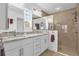 Bright bathroom featuring dual sinks, granite countertops, and a tiled walk-in shower at 10367 Addison Shore Way, Oxford, FL 34484