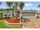 Charming home with a brick paver driveway, a two-car garage, and well-maintained landscaping at 10367 Addison Shore Way, Oxford, FL 34484