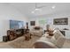 Cozy living room with white furniture, decorative rug, ceiling fan, and entertainment center at 10367 Addison Shore Way, Oxford, FL 34484