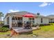 Outdoor patio featuring brick pavers, table and chairs, with well-maintained lawn and landscaping at 10367 Addison Shore Way, Oxford, FL 34484
