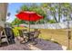 Outdoor patio with a table and chairs, umbrella, and a grill overlooking the backyard at 10367 Addison Shore Way, Oxford, FL 34484