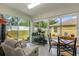 Bright sunroom with tile flooring, comfortable seating, dining set and peaceful views of the backyard at 10367 Addison Shore Way, Oxford, FL 34484