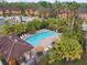 Community pool with lounge chairs and umbrellas, lush landscaping, and well-maintained townhomes in the background at 6109 Apollos Corner Way, Orlando, FL 32829