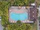Overhead view of community pool surrounded by lounge chairs, umbrellas, lush landscaping, and a community building at 6109 Apollos Corner Way, Orlando, FL 32829