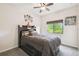 Cozy bedroom featuring a queen-size bed, a ceiling fan, and a window with views of lush greenery outside at 6109 Apollos Corner Way, Orlando, FL 32829