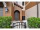 Close up of the townhome entrance, featuring a brown door, lantern, and a small garden at 6109 Apollos Corner Way, Orlando, FL 32829