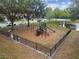 Community playground with multiple slides, climbing structure, and a pond in a black metal fenced area at 6109 Apollos Corner Way, Orlando, FL 32829