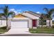 Charming single-Gathering home with a well-manicured lawn, a red door, and a two-car garage at 1022 Foreshore Ln, Haines City, FL 33844
