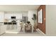 Open-concept kitchen and dining area featuring stainless steel appliances, breakfast bar seating, and modern decor at 1309 Acorn Meadow Loop, Eustis, FL 32726