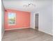 Bedroom with light gray floors, peach accent wall, window with blinds, and open walk-in closet at 1300 Holly Glen Run, Apopka, FL 32703