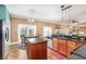 Open kitchen with wood cabinets, granite counters, island, and view to living spaces at 1300 Holly Glen Run, Apopka, FL 32703